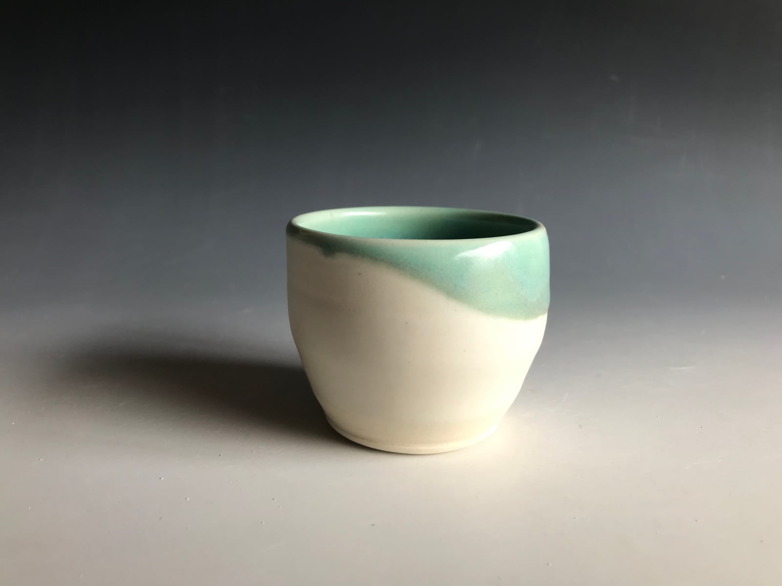 White cup with a celadon dip